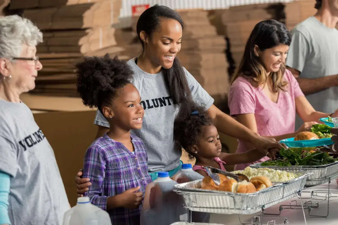 Volunteers of all ages serve food, showcasing different types of community service.