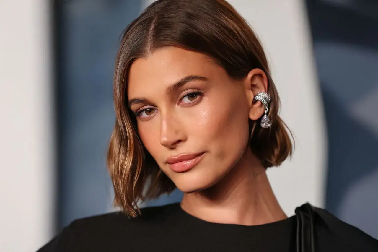 Mujer con un corte de pelo estilo italian bob, luciendo un pendiente llamativo y maquillaje natural.