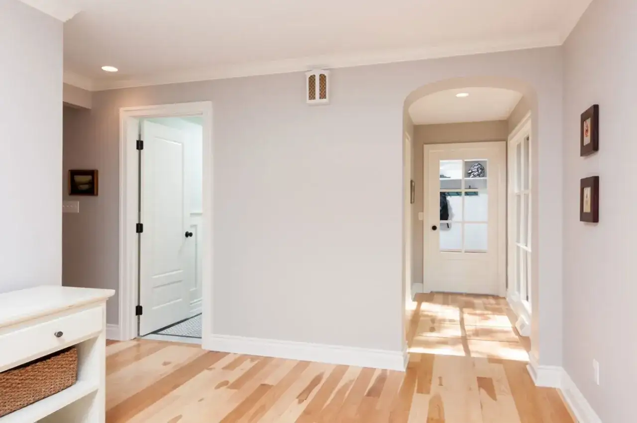 Pasillo con puertas y ventanas, destacando los distintos tipos de molduras de madera en techos y z&oacute;calos.