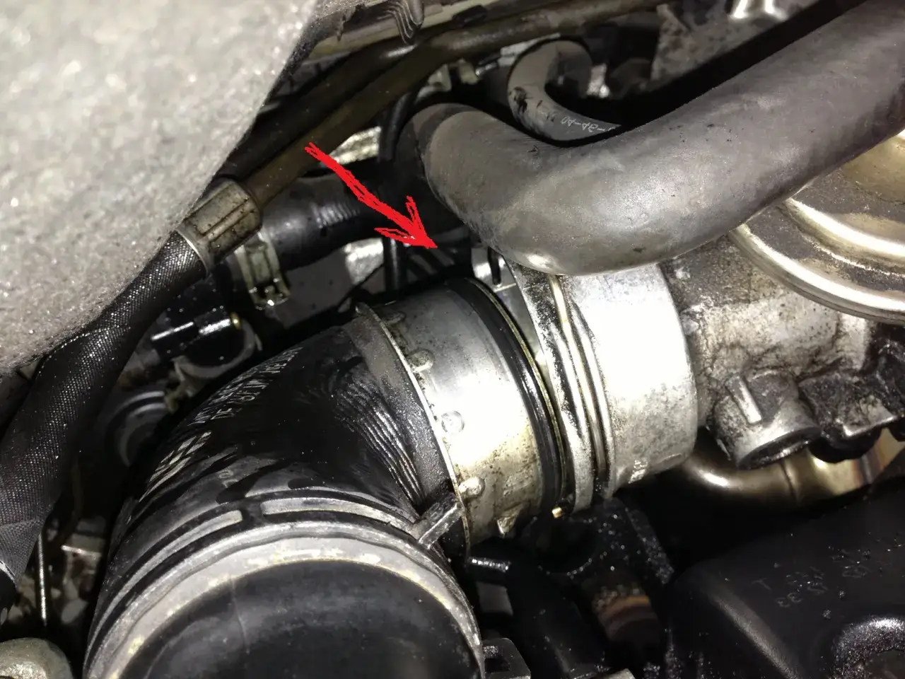 Fl&egrave;che rouge indique une durite turbo perc&eacute;e, suintant de l'huile moteur.