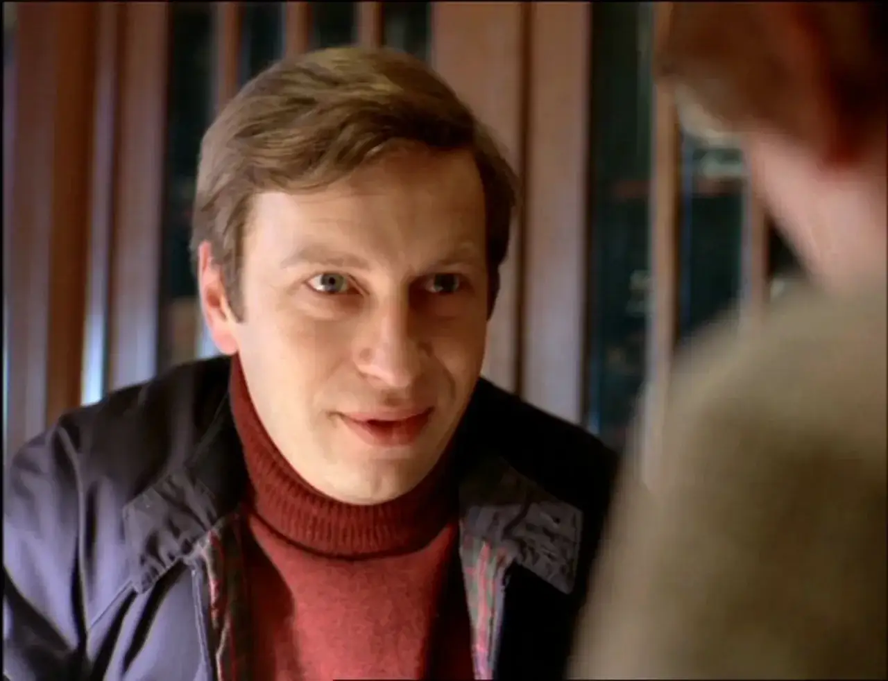 Zbliżenie na twarz mężczyzny w bordowym golfie i granatowej kurtce, jakby z jednego z filmów Feliksa Falka.