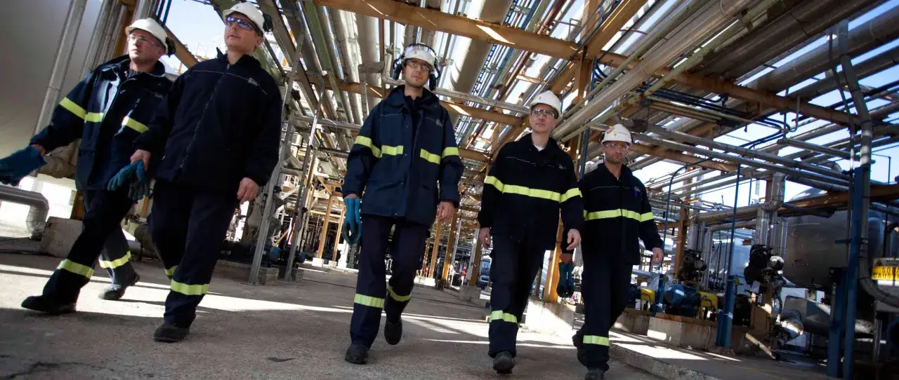 Operai in un impianto industriale. Eni assume 50 diplomati e laureati per nuove opportunità.
