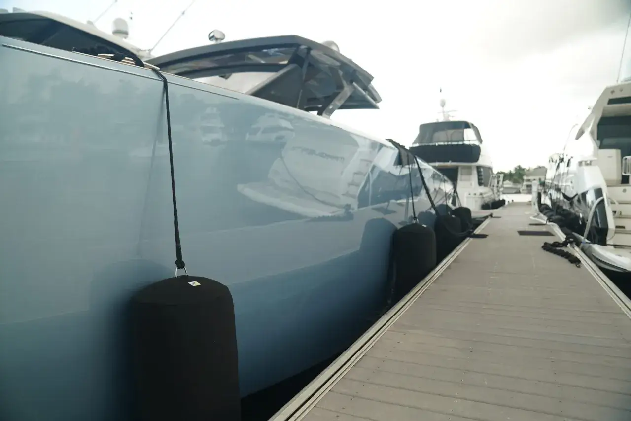 Yachts amarrés, avec des pare-battage noirs protégeant la coque bleue. Ces coussins gonflables servent de pare-chocs, une définition pratique pour le pare-battage.