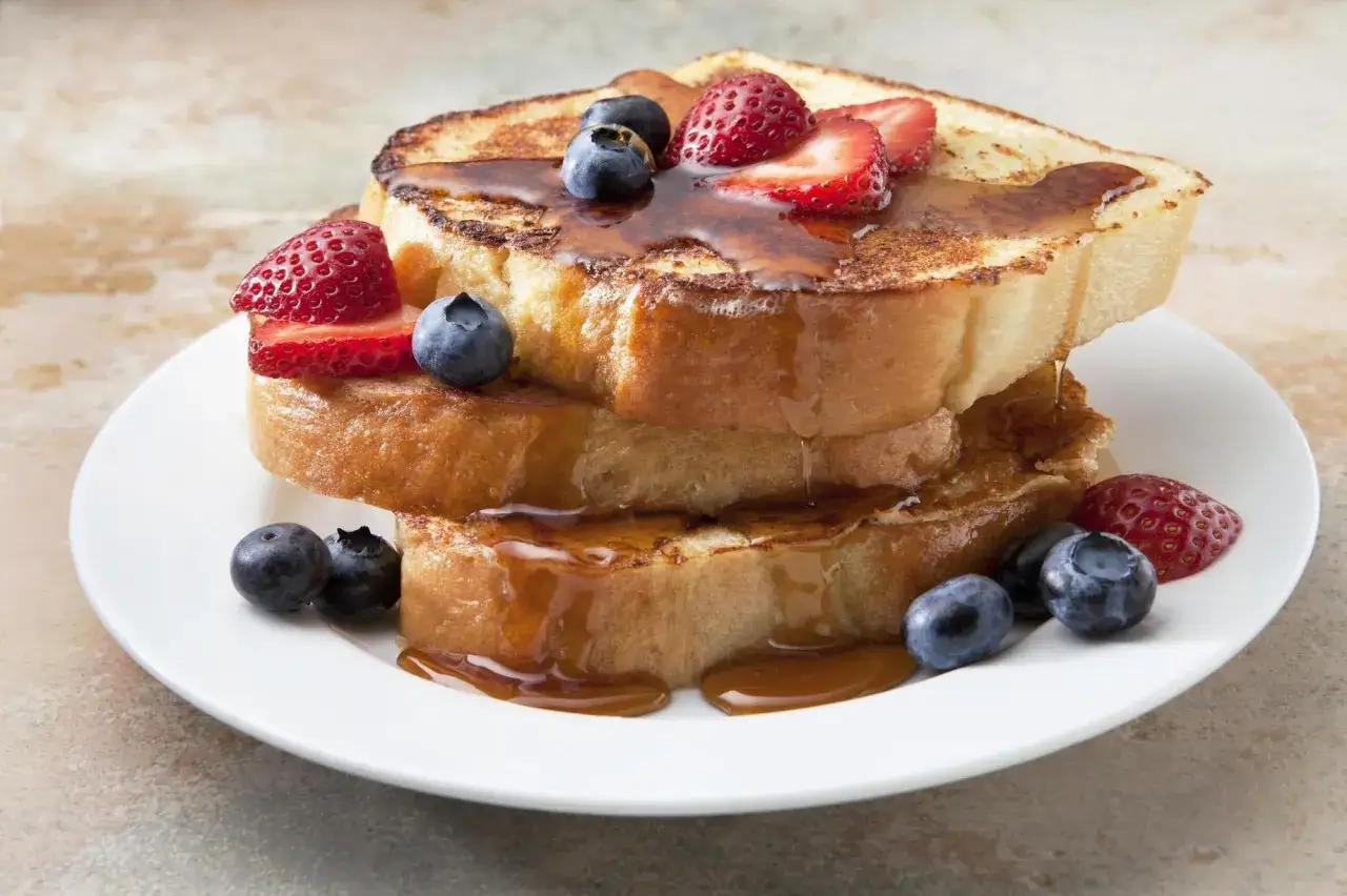 Torre de tostadas francesas con fresas y arándanos, bañadas en sirope. ¡Una deliciosa french toast receta!