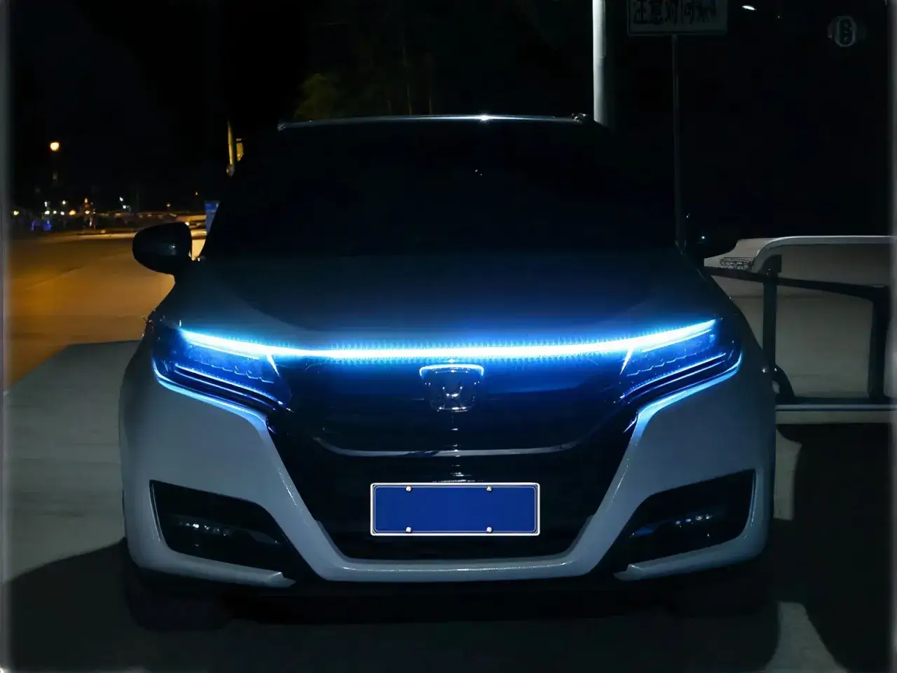 Voiture avec éclairage LED bleu vif sur le capot, parfait pour installer un look unique.