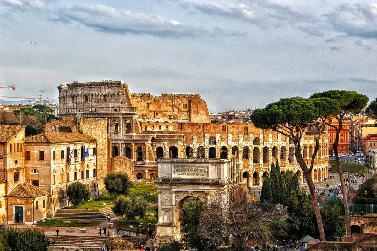Una giornata a Roma: il Colosseo e l'Arco di Tito dominano il paesaggio, con pini marittimi che incorniciano la scena storica.