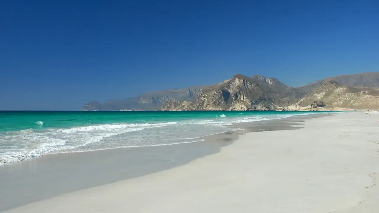 Piękna plaża z turkusową wodą i skalistymi górami w tle. Tak właśnie wygląda Oman.