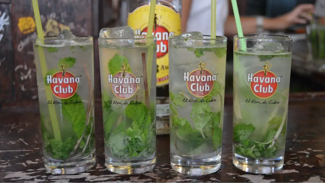 Cztery orzeźwiające mojito z rumem Havana Club, lodem i miętą, gotowe do degustacji.