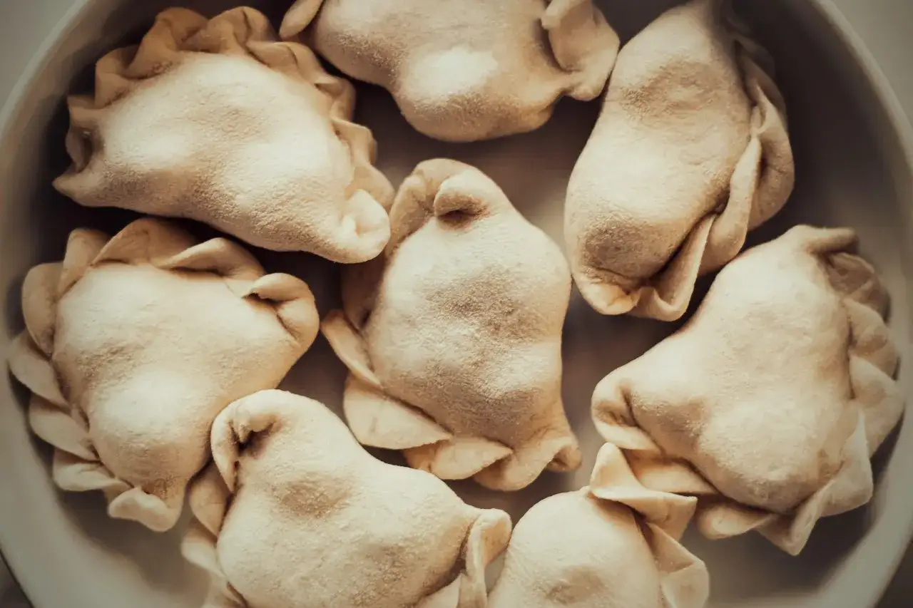 Surowe pierogi w misce. Zastanawiasz się, czy płukać pierogi po ugotowaniu? Te wyglądają apetycznie!