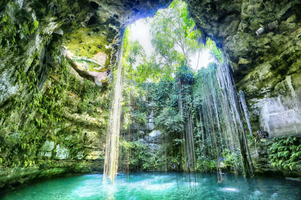 El cenote Ik Kil, una maravilla natural con aguas turquesas y cascadas de vegetaci&oacute;n colgante.