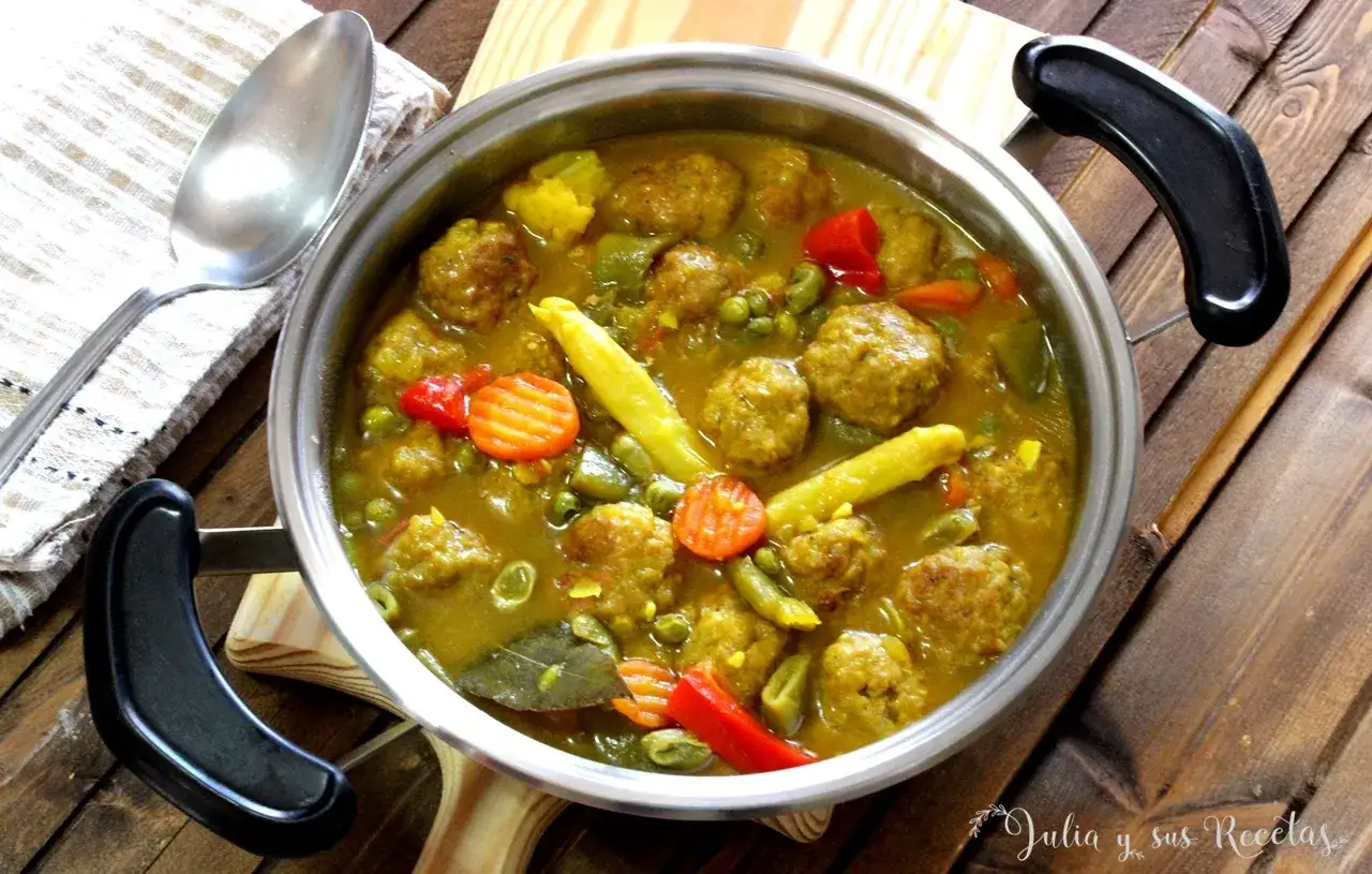 Albondigas a la jardinera en una olla, con guisantes, zanahoria y pimientos. Un plato casero y reconfortante.