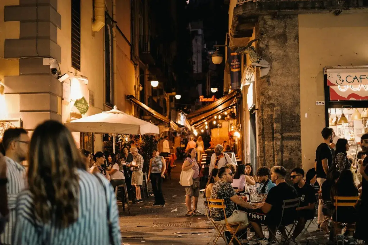 Serata animata in un vicolo di Napoli, tra locali e gente che si gode la vita notturna, tra i migliori club di Napoli.