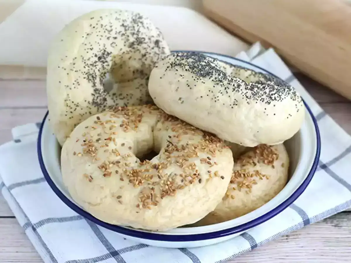 Färska bagels med vallmofrön och sesamfrön i en skål. Ett perfekt bagels recept för hemmabruk.
