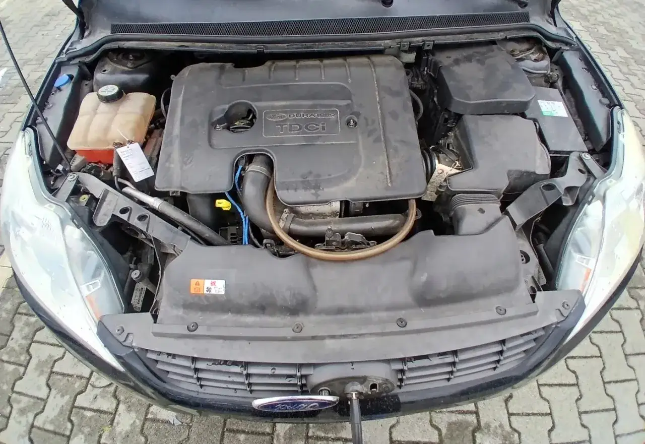 Silnik Duratorq TDCi w Fordzie Focus MK2 1.6 TDCI. Widoczny zbiornik płynu chłodniczego i elementy układu dolotowego.