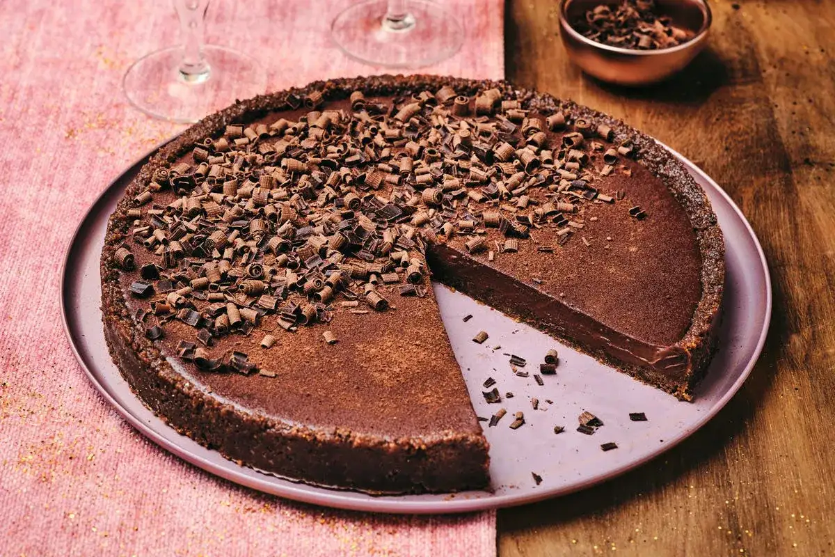 Une délicieuse tarte chocolat légère, garnie de copeaux de chocolat et saupoudrée de cacao. Parfaite pour un dessert gourmand.