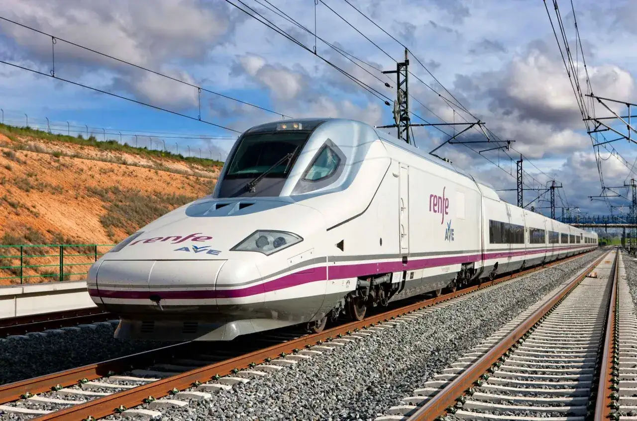 Tren AVE Renfe blanco y morado, listo para viajar de Valencia a Sevilla.