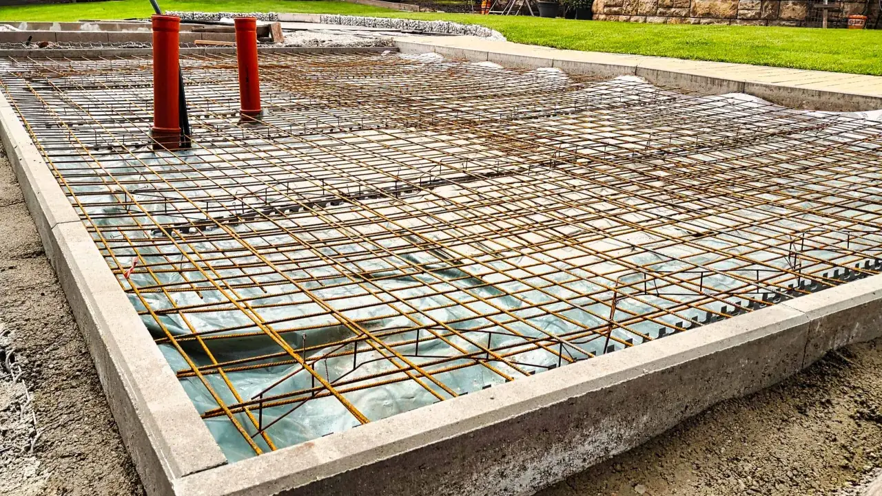 Bewehrung f&uuml;r eine Betonplatte, bereit f&uuml;r den Portlandzement-Verwendung. Rohre ragen aus der Stahlmatte.