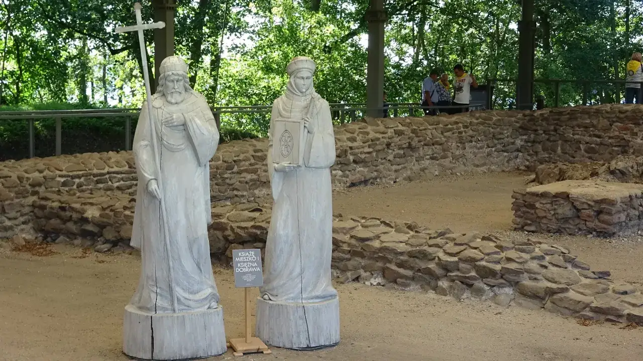 Dwie drewniane rzeźby przedstawiające Mieszka I i Dobrawę, stojące na terenie, gdzie odbył się chrzest polski.