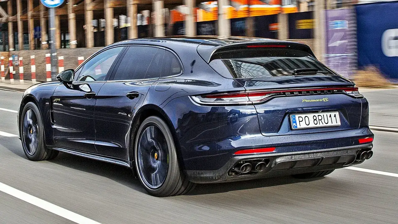 Ciemnoniebieskie Porsche Panamera 4S na drodze. Sprawdź aktualną porsche panamera cena.