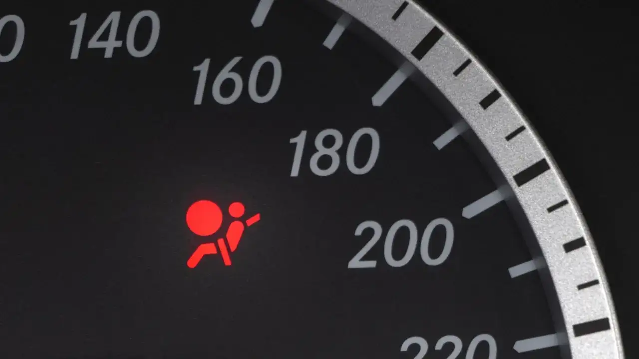Luz de advertencia roja de airbag encendida en el tablero. Indica un problema con los tipos de airbag, que requieren atenci&oacute;n.