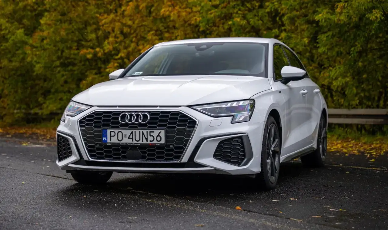 Białe Audi A3 na tle jesiennych drzew. Sprawdź atrakcyjną audi a3 cena i wybierz swój wymarzony samochód.