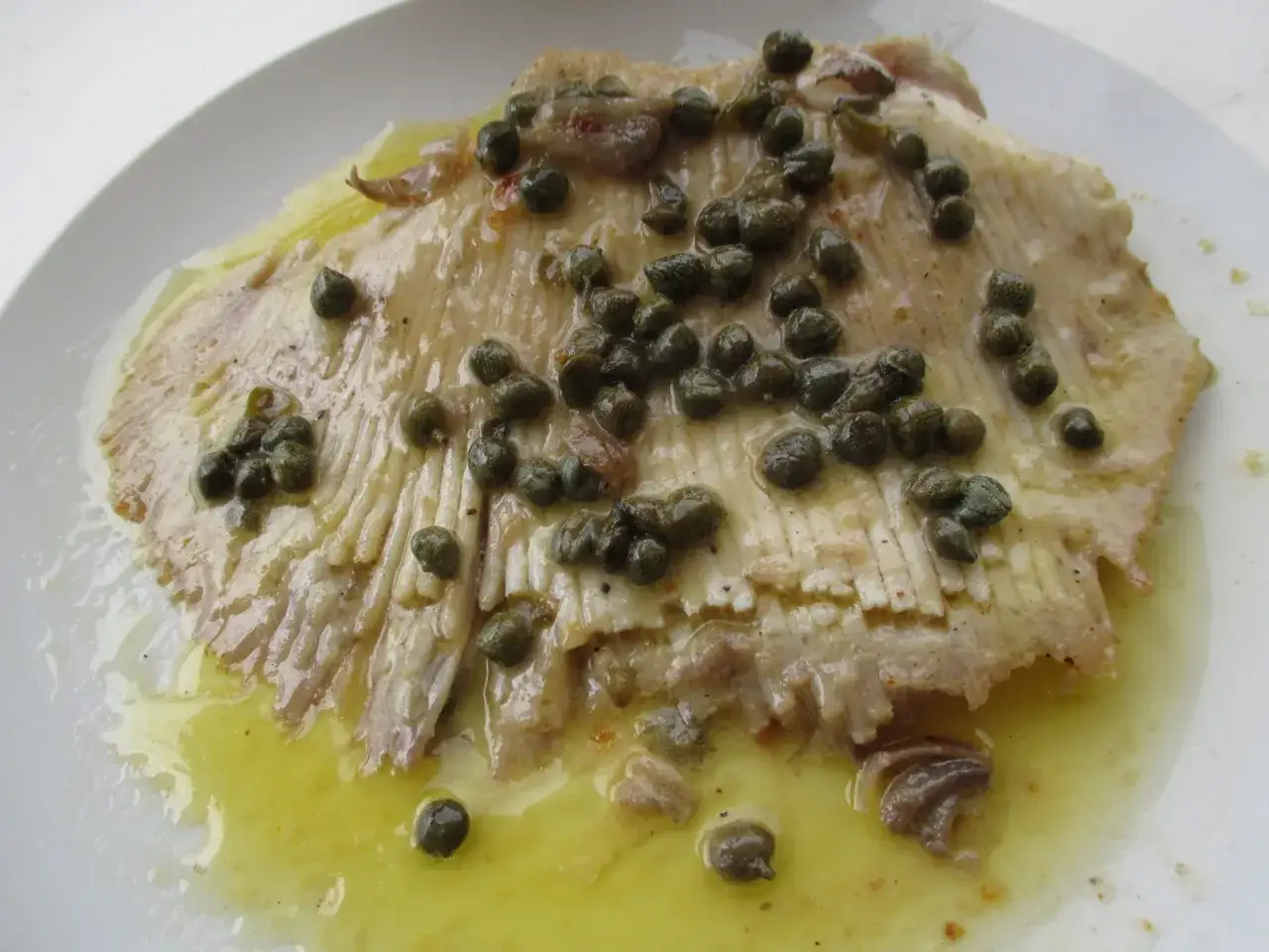Une aile de raie poêlée, nappée d'une sauce au beurre et garnie de câpres. Un délice marin.