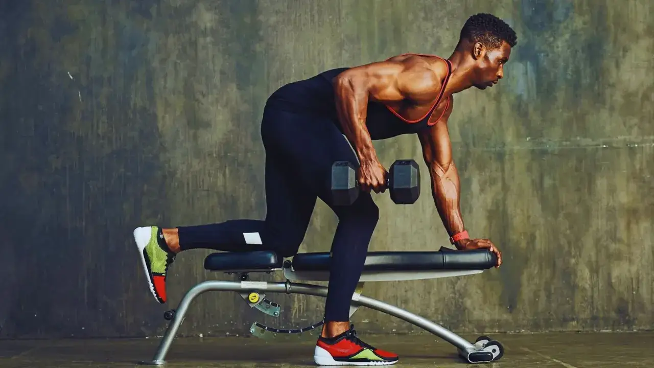 Un homme fait du rowing halt&egrave;re unilat&eacute;ral, un exercice cl&eacute; pour le musculation dos.