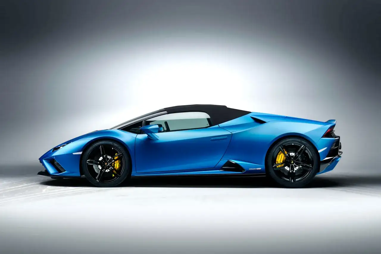 Niebieski kabriolet Lamborghini Huracan z ż&oacute;łtymi zaciskami hamulcowymi i czarnymi felgami.