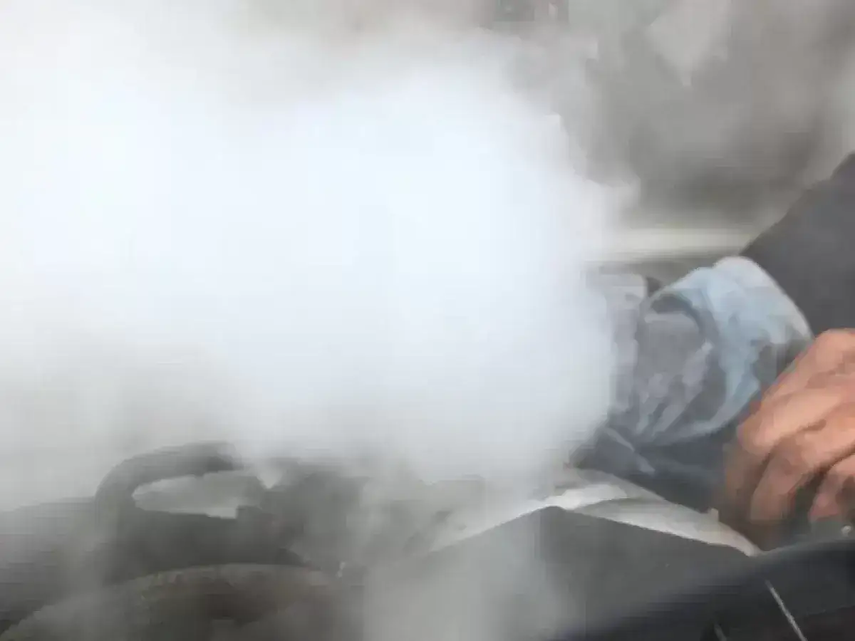 Sale humo del motor y huele a quemado. Una mano con un trapo intenta arreglarlo.
