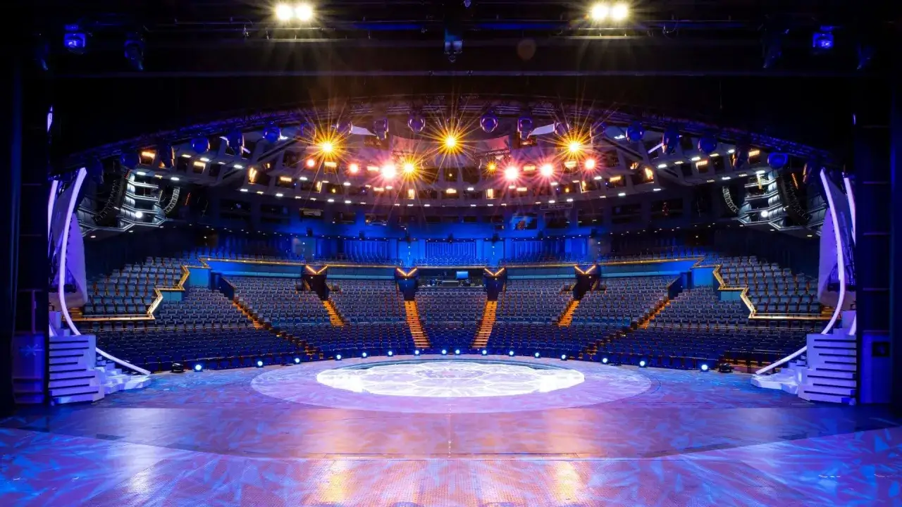Leere Zuschauertribünen und eine beleuchtete Bühne in einem Theater in Berlin, bereit für eine Show.