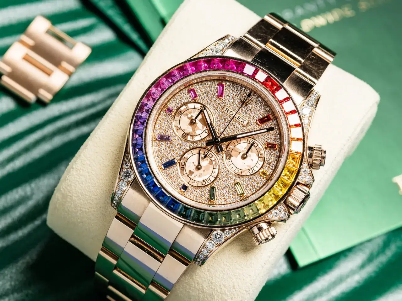 Orologio Rolex Daytona in oro rosa con diamanti e zaffiri arcobaleno. La maestria artigianale e i materiali preziosi spiegano perch&eacute; i Rolex costano cos&igrave; tanto.