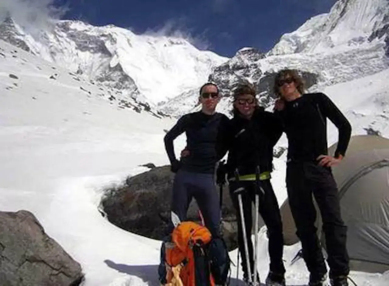 Tres amigos en la montaña, ¡pura vida Iñaki! Con equipo de expedición y un cielo azul intenso.