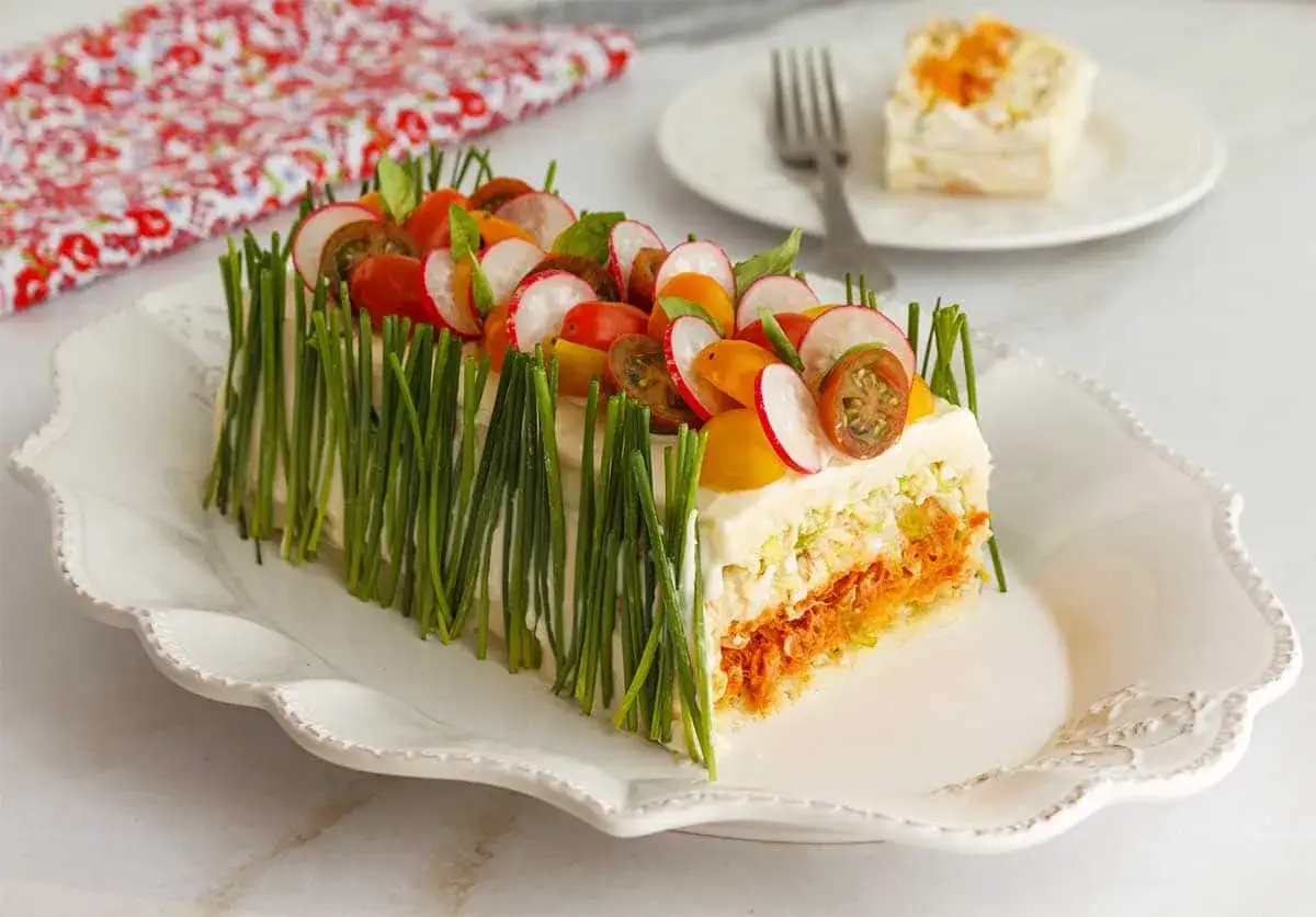 Pastel fr&iacute;o de at&uacute;n, decorado con cebollino, r&aacute;banos y tomates cherry. &iexcl;Una delicia fresca y colorida!