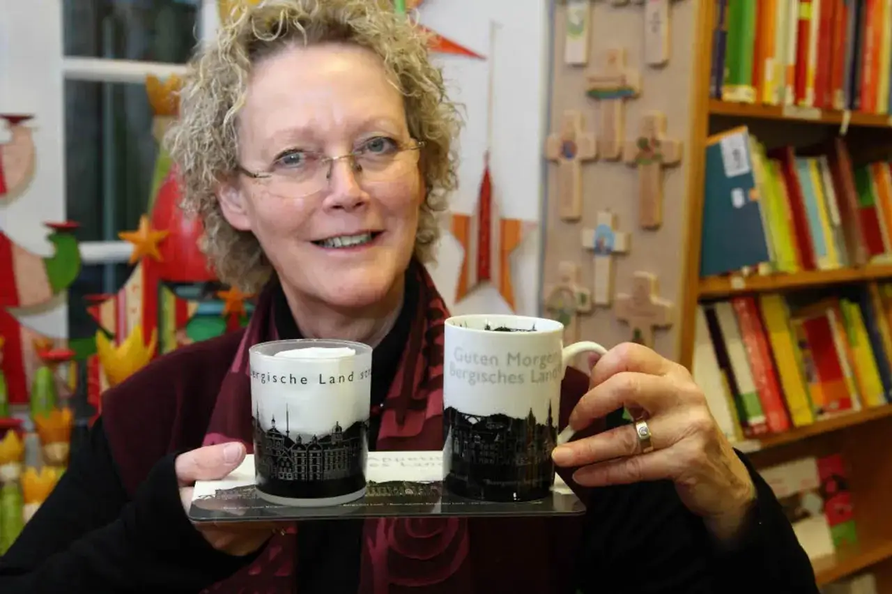 Frau im altenberger domladen h&auml;lt Tasse mit 