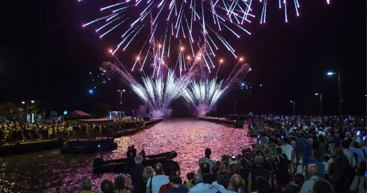 Spettacolo pirotecnico mozzafiato sulla riviera romagnola per il Ferragosto, con migliaia di persone che ammirano i fuochi d'artificio sul mare.