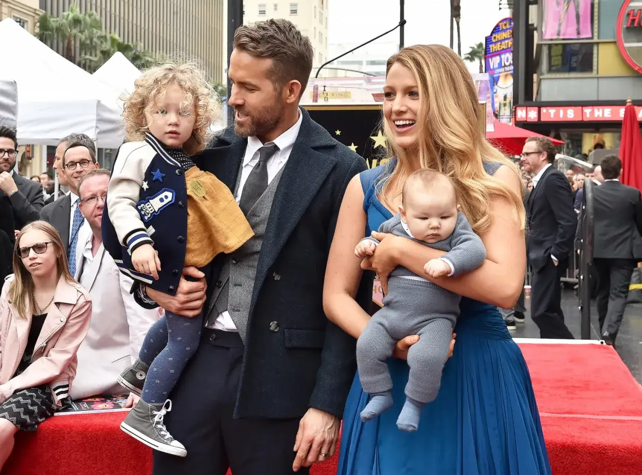 Blake Lively dzieci: Ryan Reynolds trzyma córkę, a Blake Lively tuli niemowlę. Rodzina na czerwonym dywanie.