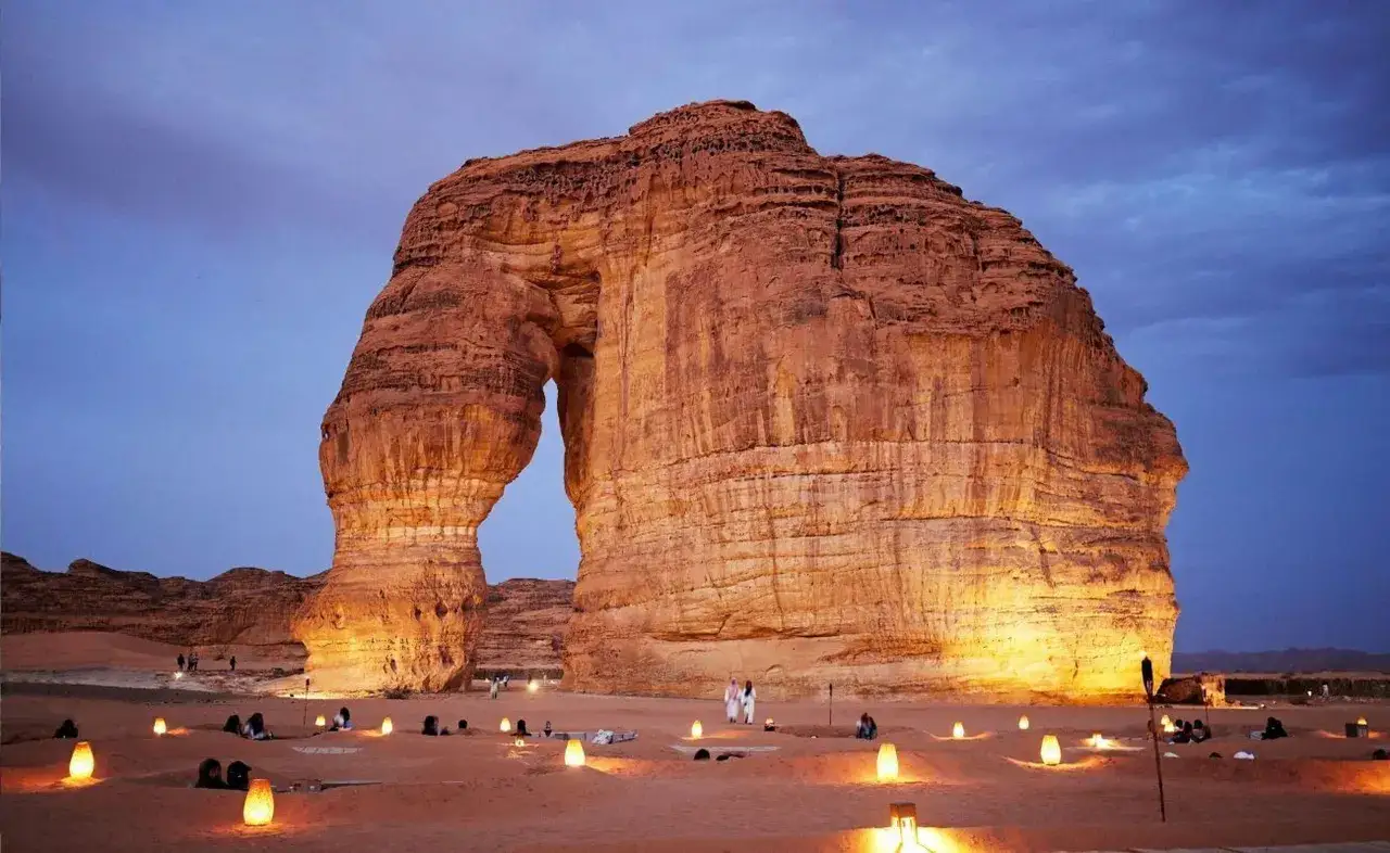 Formazione rocciosa naturale a forma di elefante, illuminata da luci soffuse nel deserto. Un luogo magico da scoprire tra le meraviglie da vedere in Arabia Saudita.