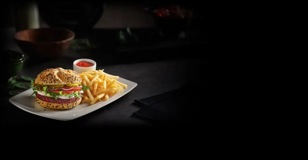 Pyszny, wegetariański konkret burger z Orlenu, podany z chrupiącymi frytkami i ketchupem.