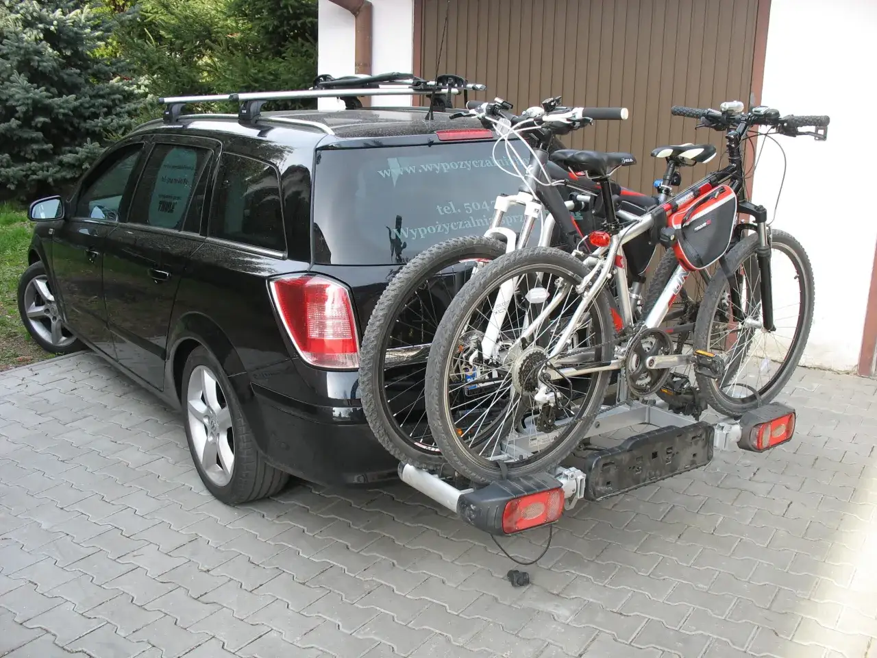 Czarny kombi z dwoma rowerami na bagażniku. Ile rowerów na dachu? Żadne, te są z tyłu!