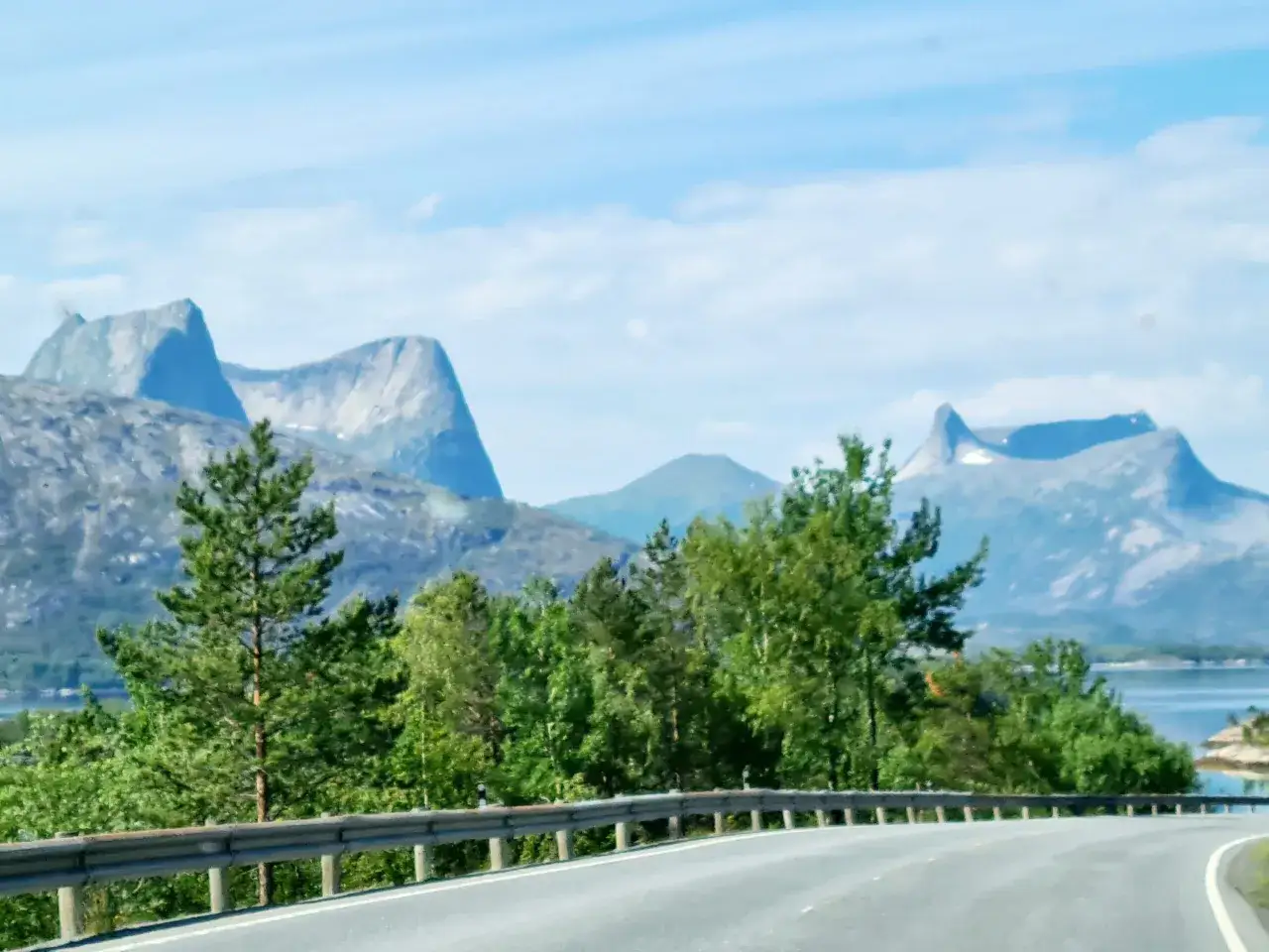 Vacker norsk kustväg med berg i bakgrunden. Perfekt för en roadtrip, men glöm inte att kolla inreseregler Norge innan du åker.