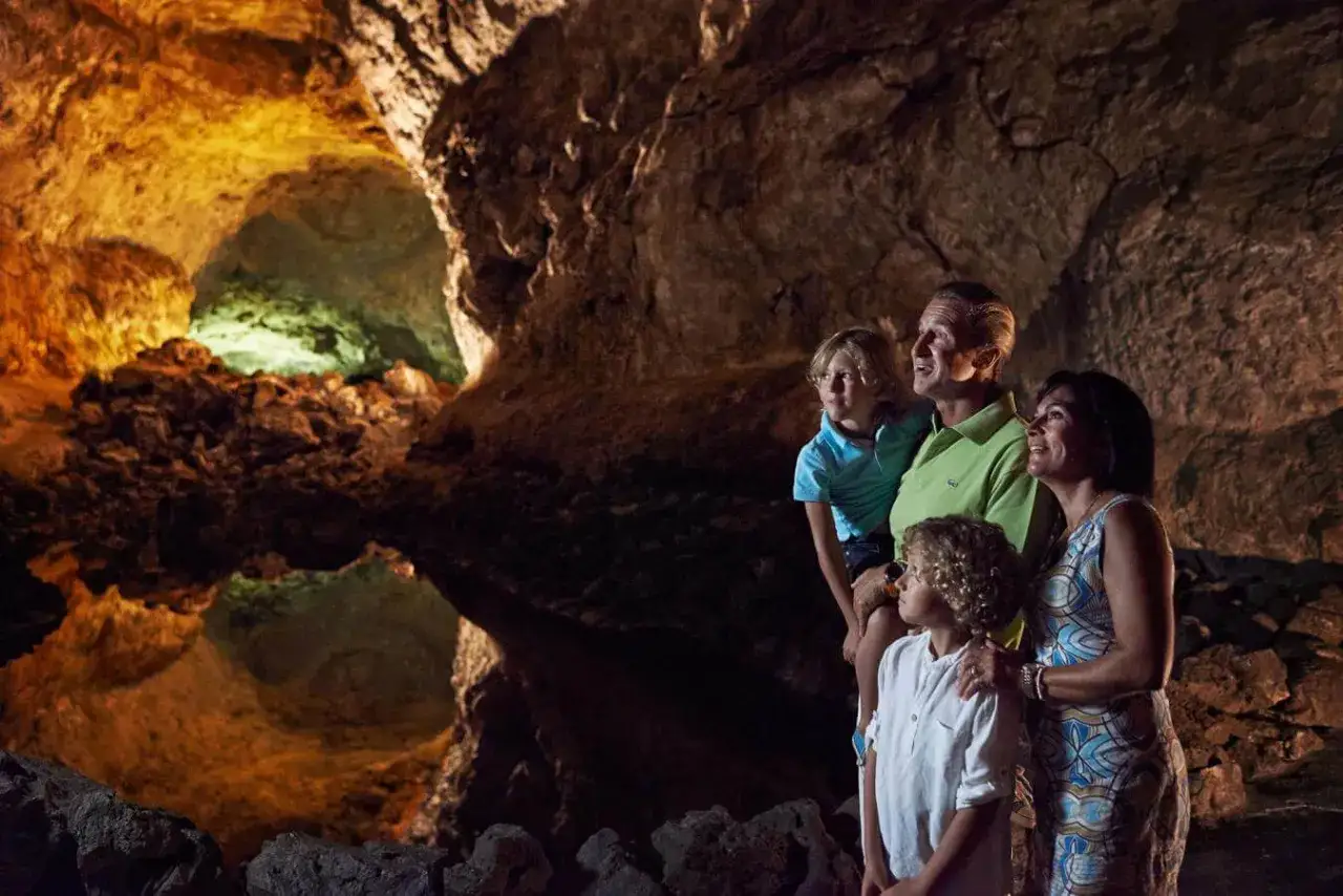 Familia explorando cuevas volcánicas en Lanzarote. Una aventura ideal para excursiones Lanzarote con niños, descubriendo formaciones rocosas únicas.
