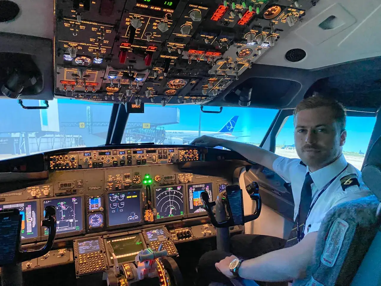 Pilot w kokpicie symulatora lotu. Zastanawiasz się, ile kosztuje licencja pilota? To inwestycja w marzenia o przestworzach.
