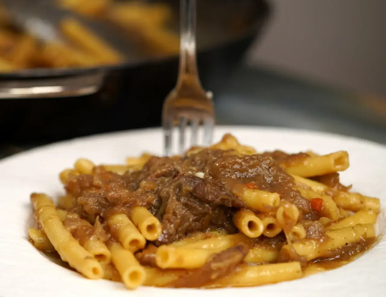 Un piatto invitante di ziti alla genovese, con la pasta che abbraccia un ricco rag&ugrave; di carne e cipolle.