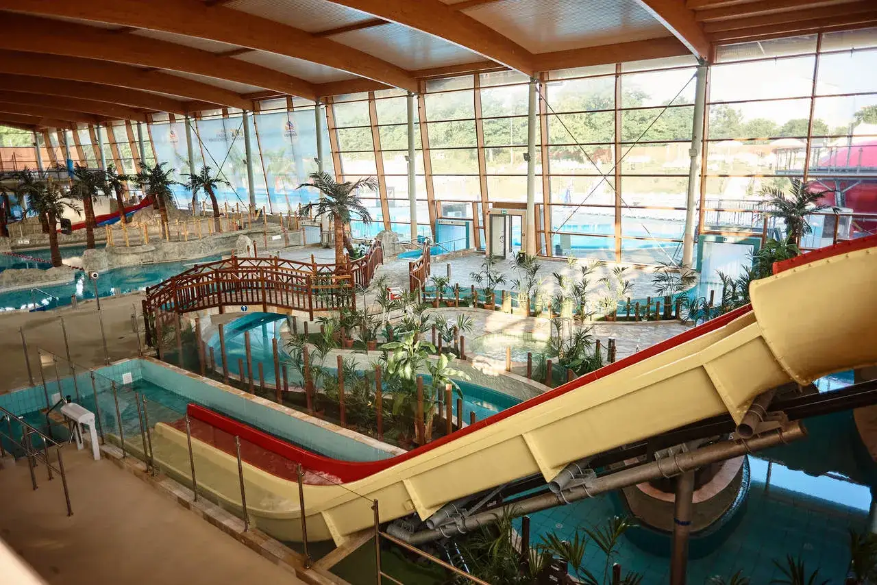 Ein tropischer Traum im Aquapark Breslau: Rutschen, Palmen und Br&uuml;cken laden zum Planschen ein.