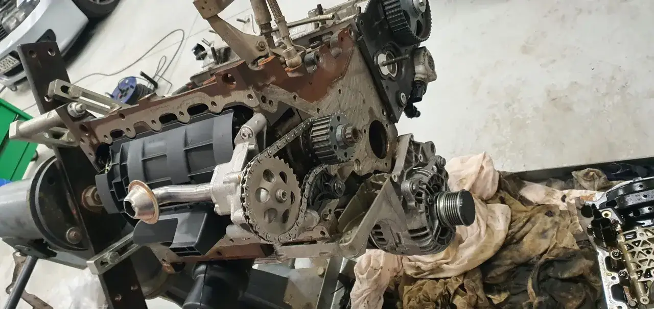 Silnik 2.0 TSI w trakcie naprawy, widoczny rozrząd łańcuchowy, koła zębate i alternator.