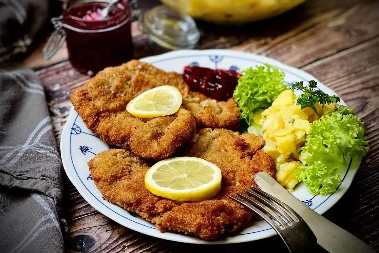Original Wiener Schnitzel mit Kartoffelsalat, Preiselbeeren und Zitrone. Ein Klassiker, der immer schmeckt.