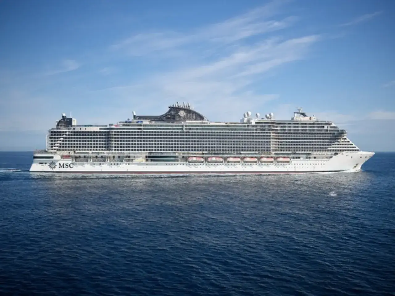 La MSC Seascape, con la sua imponente lunghezza, solca il mare blu sotto un cielo sereno.