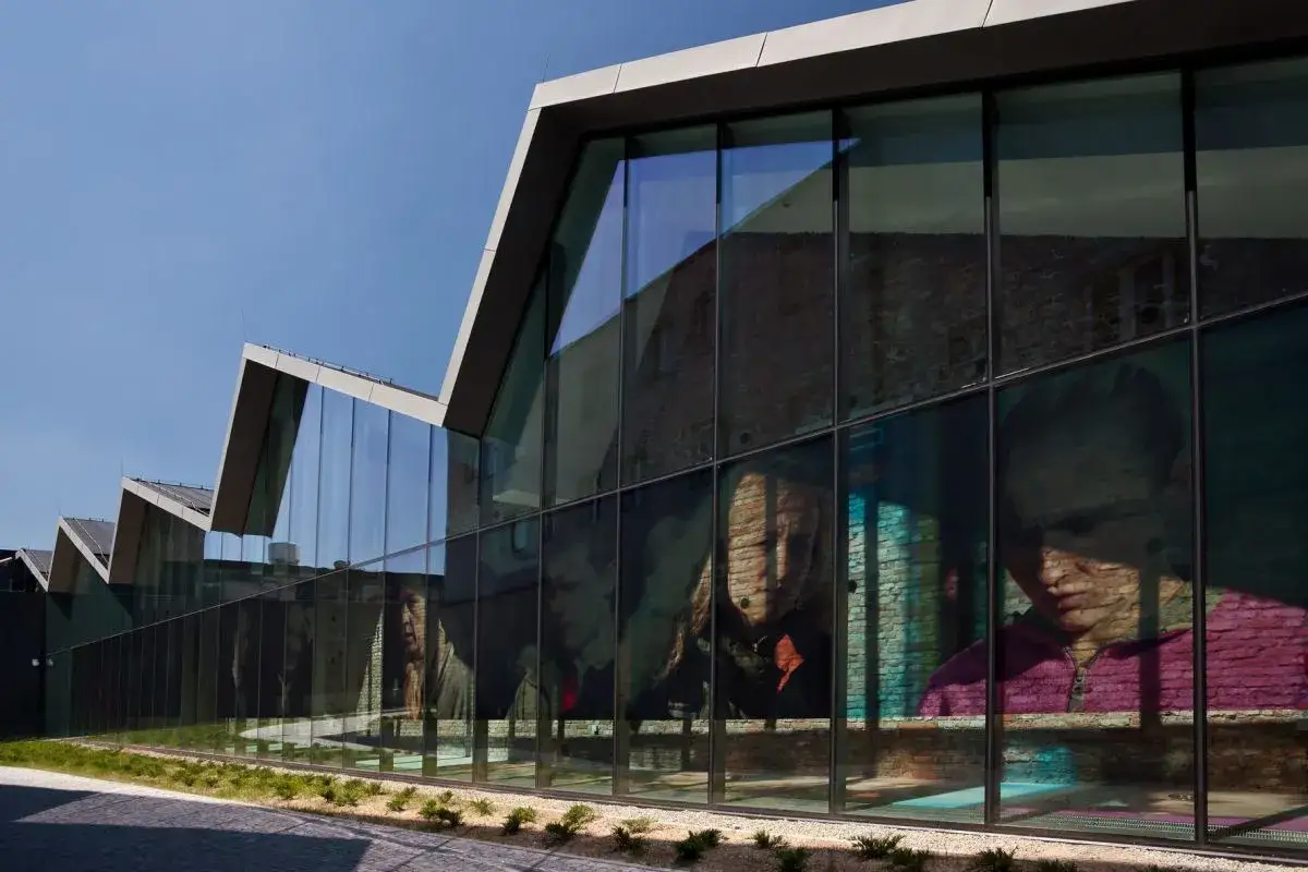 Nowoczesna architektura muzeum sztuki współczesnej Kraków z wielkoformatowymi portretami na szkle.