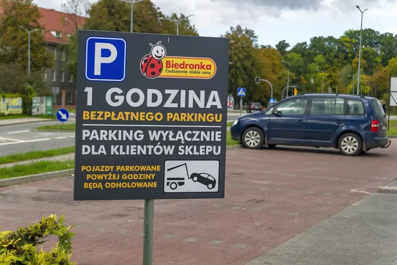 Tablica informuje o 1 godzinie bezpłatnego parkingu dla klientów Biedronki. Pojazdy parkowane powyżej godziny będą odholowane.