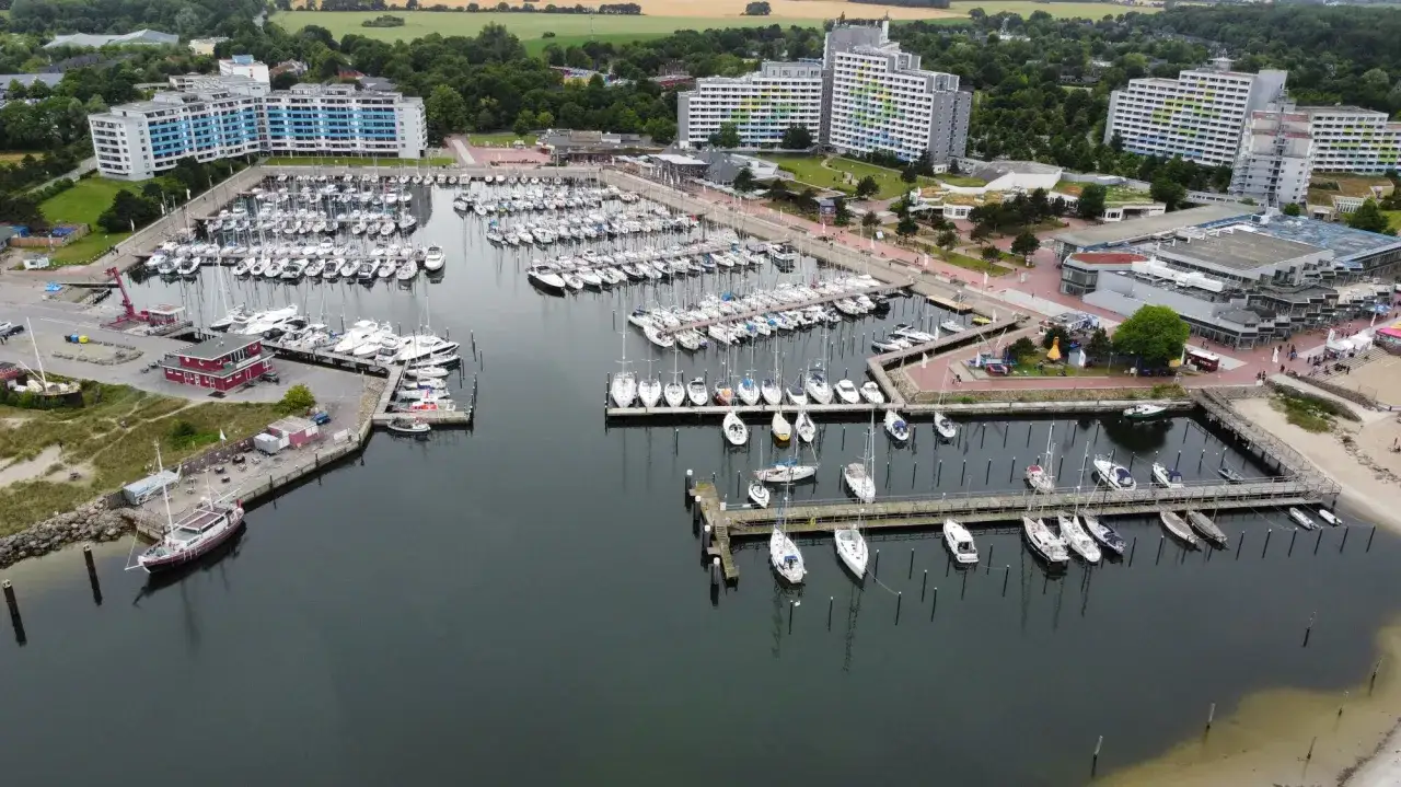 Viele Segelboote und Yachten liegen im dampfenden Hafen von Damp. Moderne Gebäude säumen die Küste.